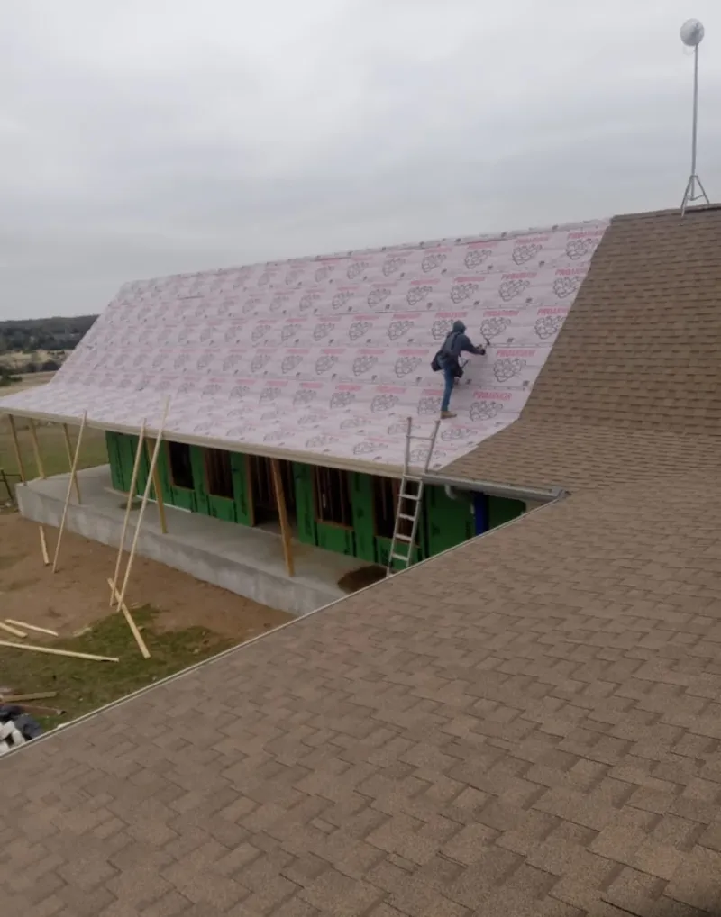 Worker preparing underlayment for a metal roof installation in Town 'n' Country
